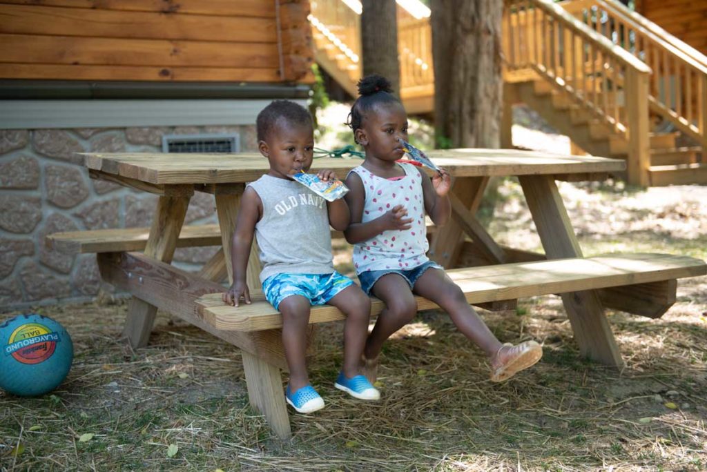 Two Cute Kids Drinking Juices at Picnic Table at Wilderness Presidential Resort