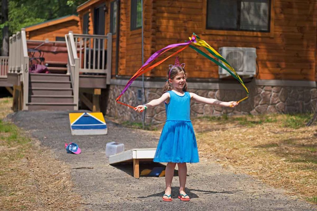 Little girl playing outside a Wilderness Presidential Resort camp cottage