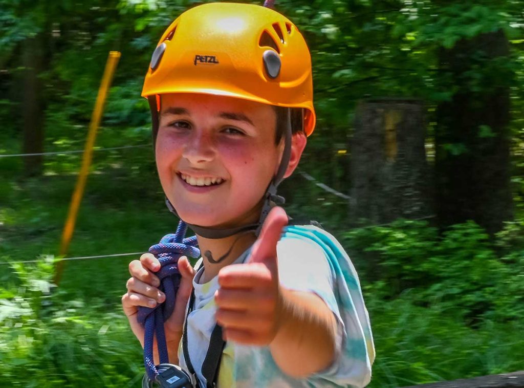 happy boy completes adventure park ropes course