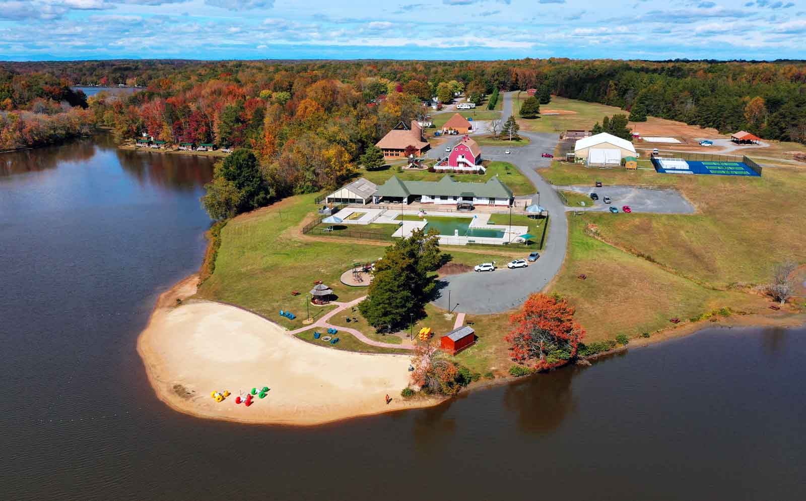aerial drone photo of wilderness presidential resort beach and indoor pool by lake and camping cabins