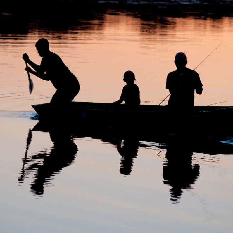 Kids fishing with parent at dusk stock image